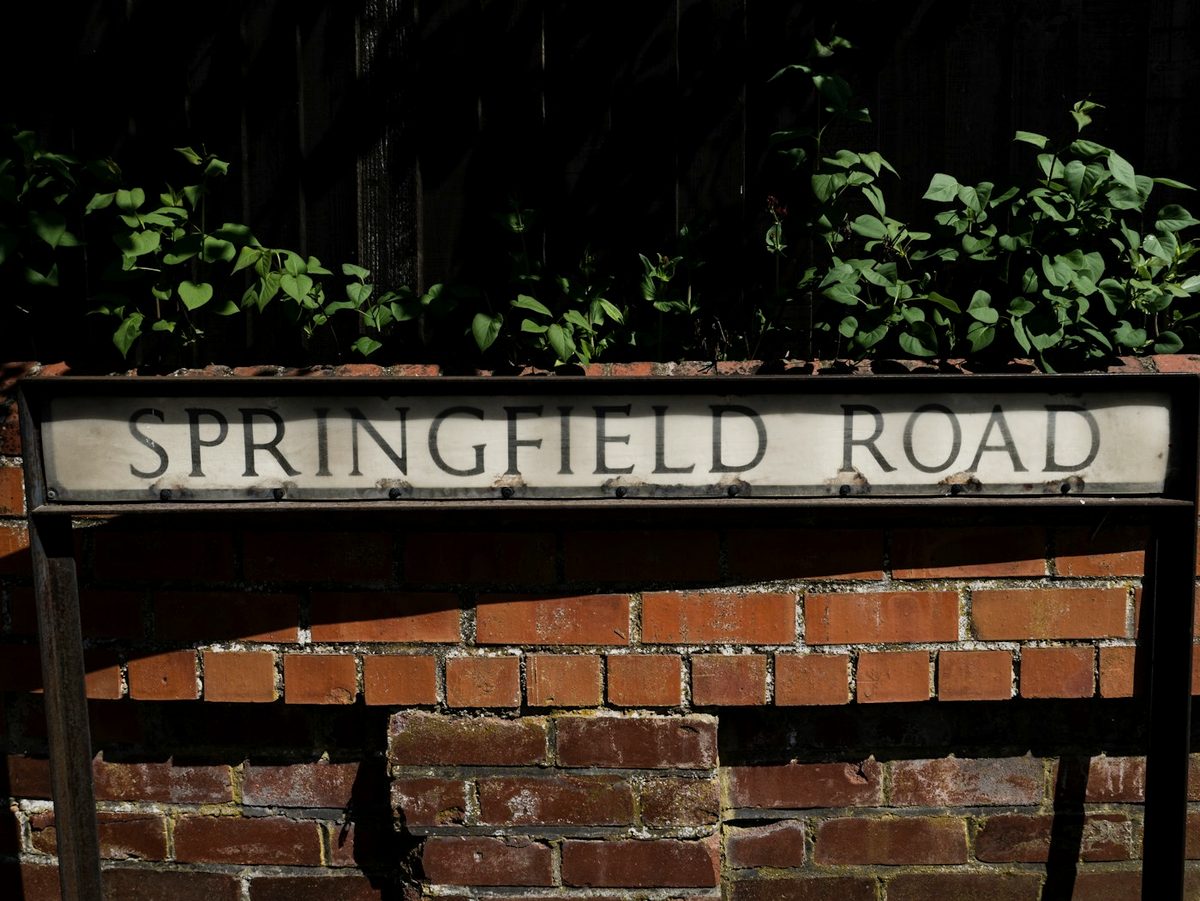 A British residential street sign mounted on a red brick wall.